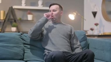 Koltukta otururken öksüren sıradan bir adam. 