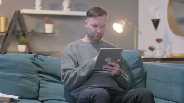 Випадкове керування планшетом сидячи на дивані — стокове відео