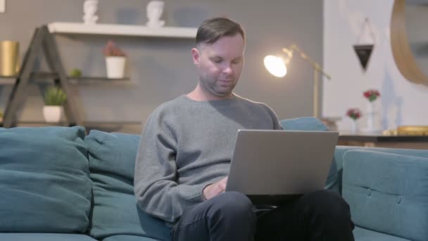 Alkalmi Manwith Laptop, amelynek csuklófájdalom a kanapén — Stock videók