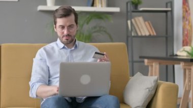Genç adam internette ödemesini yapıyor. Dizüstü bilgisayarda. 