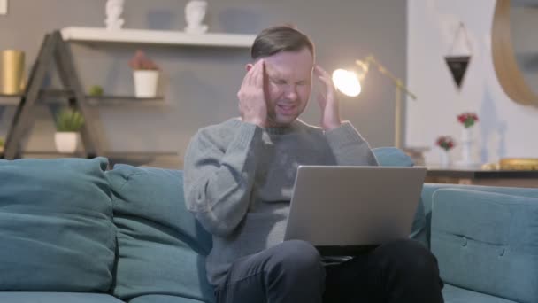 Casual Manwith Laptop met hoofdpijn op de bank — Stockvideo