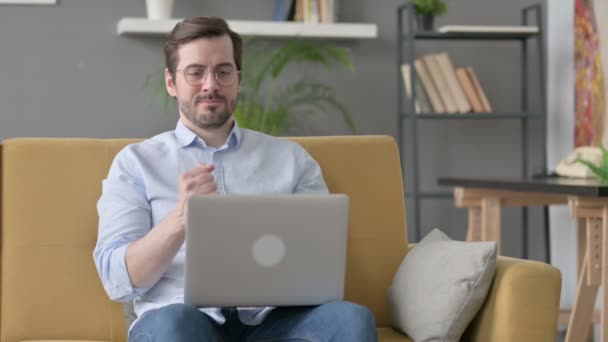 Junger Mann mit Laptop hat Handgelenkschmerzen auf Sofa — Stockvideo