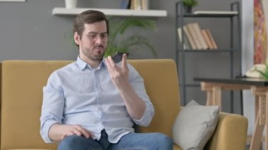 Sinirli genç adam akıllı telefondan konuşuyor. 