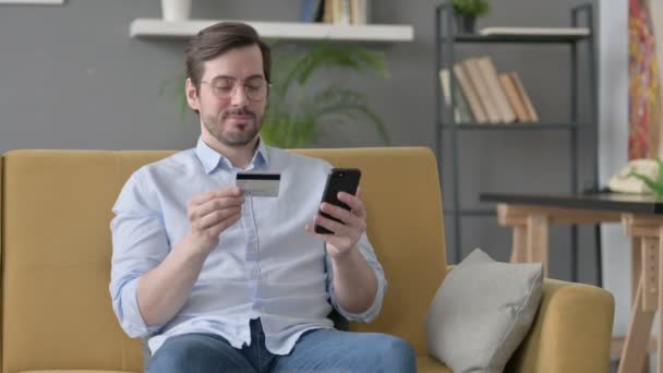 Молодий чоловік робить онлайн платежі на смартфоні — стокове відео