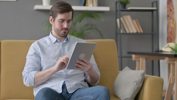 Homem jovem usando Tablet no sofá — Vídeo de Stock