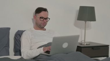 Middle Aged Man having Back Pain while using Laptop in Bed