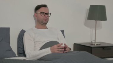 Middle Aged Man having Headache while Sitting in Bed