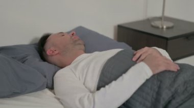 Middle Aged Man Feeling Uncomfortable while Sleeping in Bed