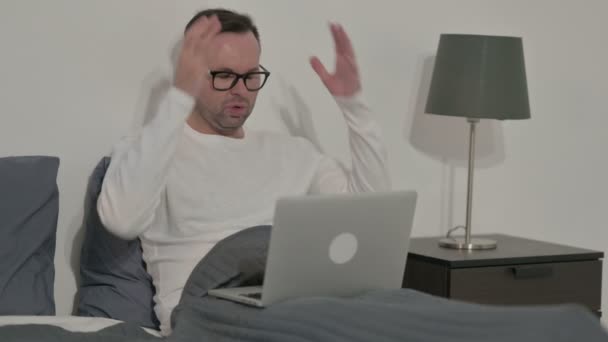 ベッドのラップトップで損失に反応する中年男性 — ストック動画