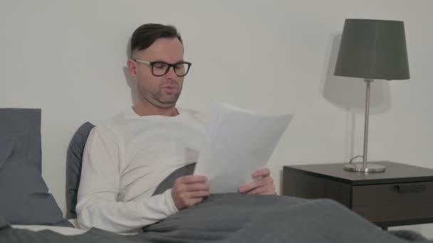 Middle Aged Man Reading Documents While Sitting Bed — Video Stock
