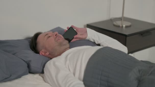 Чоловік Середнього Віку Розмовляє Телефону Під Час Сну Ліжку — стокове відео