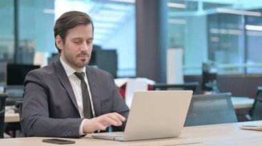 Young Businessman Standing Up and Going Away after Work