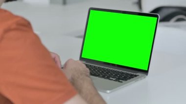 Creative Young Man Using Laptop with Green Chroma Key Screen 