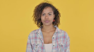 Serious African Woman Looking at the Camera on Yellow Background 