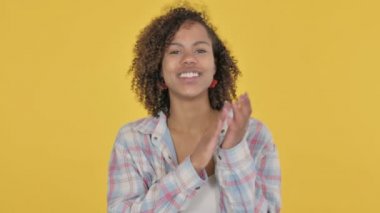 African Woman Clapping, Applauding on Yellow Background 