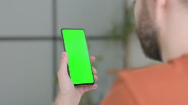 Creative Young Man Using Smartphone with Green Screen 