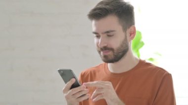 Creative Young Man Browsing Internet on Smartphone