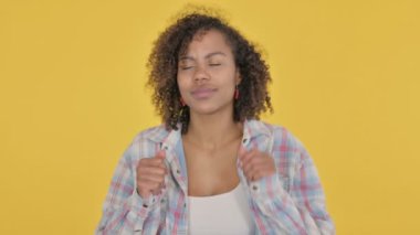 African Woman Dancing in Joy on Yellow Background 