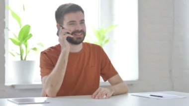 Creative Young Man Talking on Phone, Discussing Work