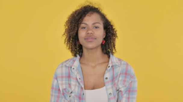 African Woman Pointing Camera Inviting Yellow Background — Stockvideo