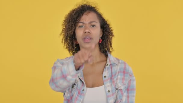 African Woman Pointing Camera Yellow Background — Stockvideo
