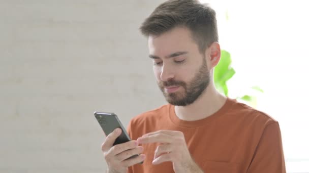 Jeune Homme Créatif Célèbre Son Succès Sur Smartphone — Video