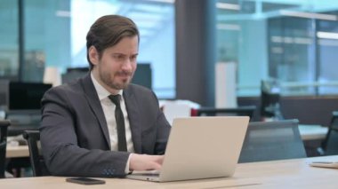 Angry Young Businessman Working on Laptop in Frustration