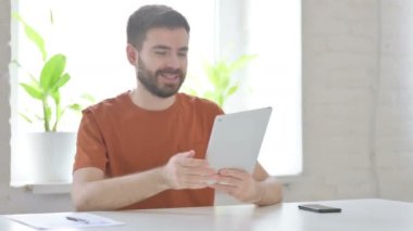 Video Call on Tablet by Creative Young Man in Office 