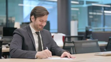 Young Businessman with Disappointment Writing on Paper