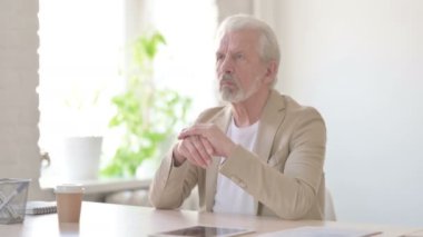 Pensive Senior Old Man Thinking while Sitting in Office