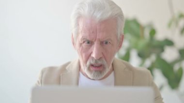 Close Up of Senior Old Man Reacting to Loss While using Laptop 