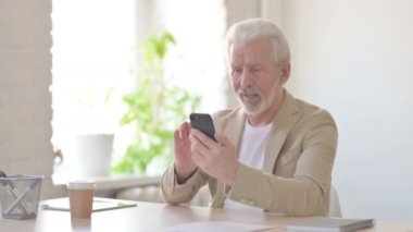 Successful Senior Old Man Celebrating on Smartphone