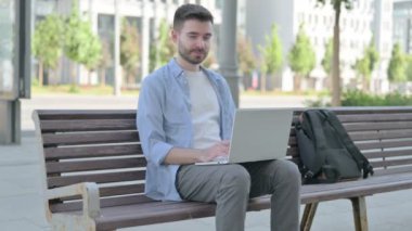 Thumbs Up by Man with Laptop Sitting on Bench 