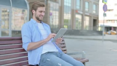 Tablet 'te Çevrimiçi Video Sohbeti Orta YaşIı Adam Bench' te Oturuyor 