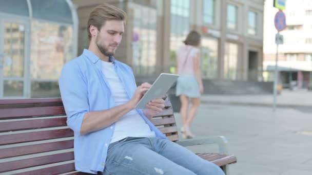 Mann Mittleren Alters Benutzt Tablet Während Draußen Auf Bank Sitzt — Stockvideo