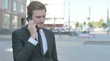 Angry Middle Aged Businessman Talking on Phone Outdoor