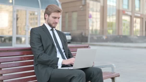 Businessman Pointing Camera While Sitting Bench Outdoor — Vídeo de stock
