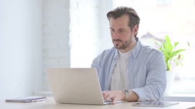 Mature Man Reacting to Loss While using Laptop 