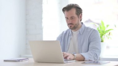 Mature Man Coughing while using Laptop 