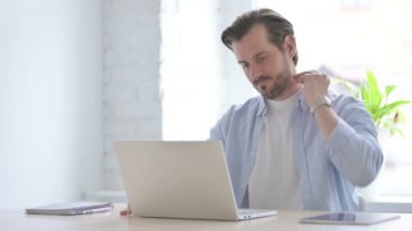 Mature Man having Neck Pain while using Laptop 