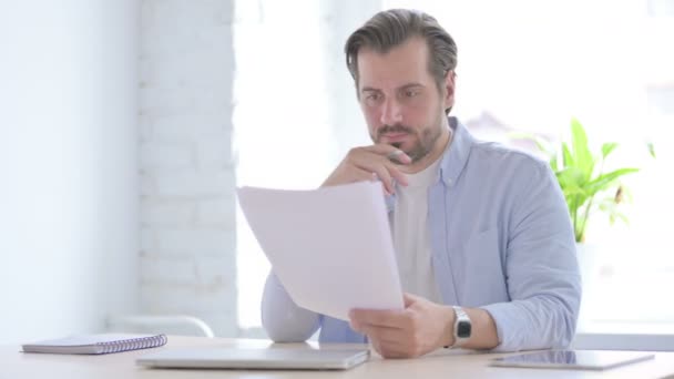 Mature Man Reading Reports While Sitting Office — Stock video