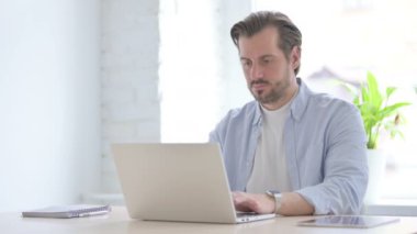 Mature Man having Headache while Working on Laptop