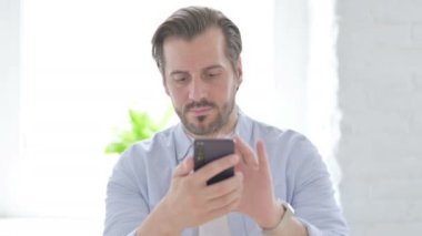 Mature Man Browsing Internet on Smartphone