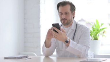 Male Doctor Talking on Phone in Clinic