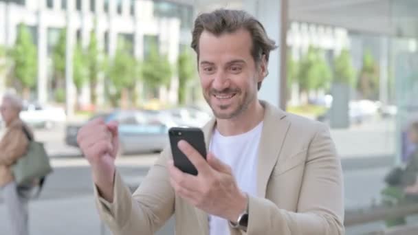 Man Celebrating Online Success Smartphone Outdoor — Video Stock