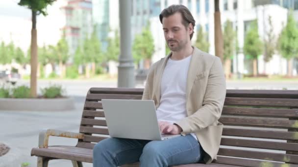 Mann Benutzt Laptop Während Auf Bank Sitzt — Stockvideo