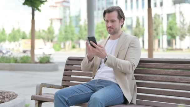 Man Reacting Loss Smartphone While Sitting Bench — Vídeos de Stock