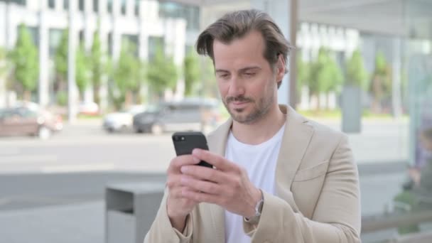 Man Browsing Internet Smartphone Outdoor — Stockvideo