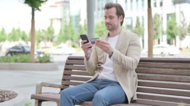 Excited Man Shopping Online via Smartphone, Outdoor
