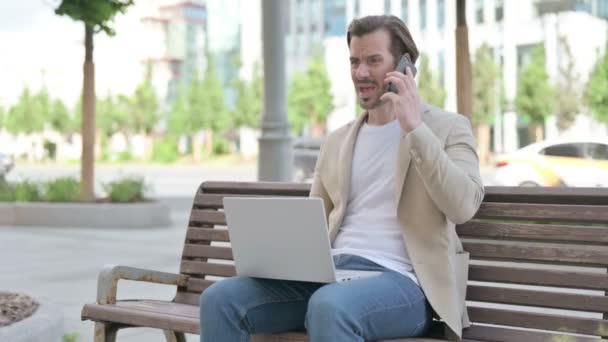 Angry Man Laptop Talking Phone While Sitting Bench — Stockvideo